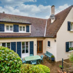 Maison traditionnelle avec jardin et terrasse.