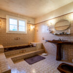 Salle de bain vintage avec baignoire marron et lavabo.