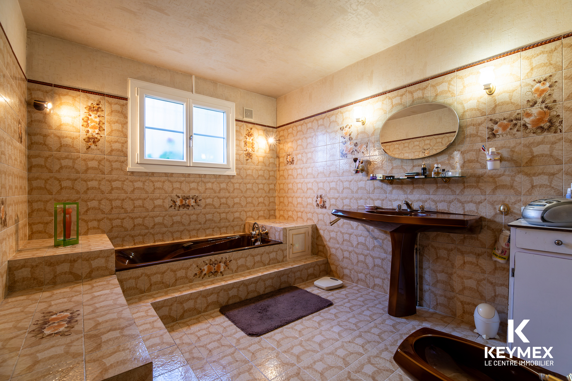 Salle de bain vintage avec baignoire marron et lavabo.