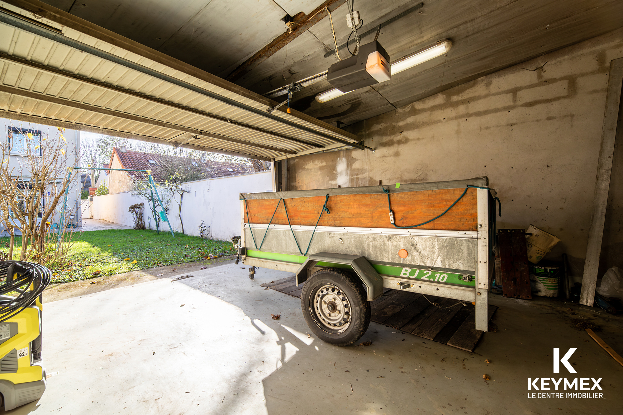 Remorque dans un garage lumineux avec jardin.