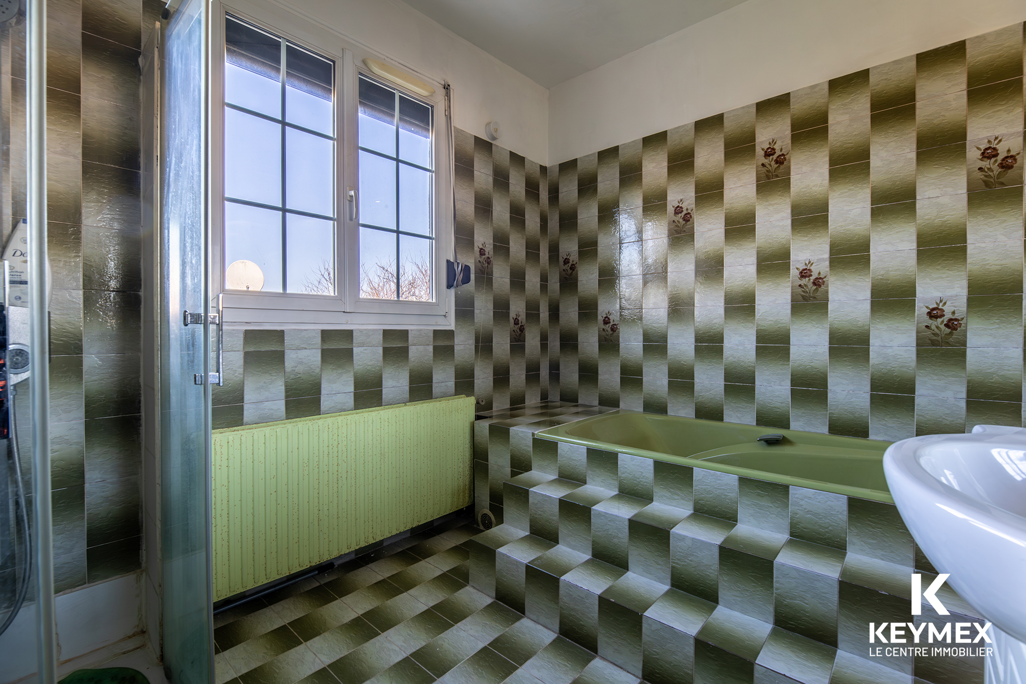 Salle de bain rétro avec carrelage vert.