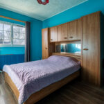 Chambre avec lit double et armoire en bois.