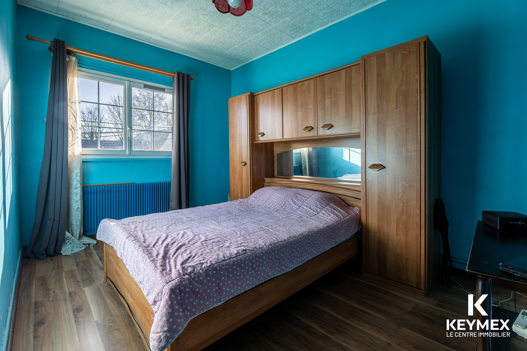 Chambre avec lit double et armoire en bois.