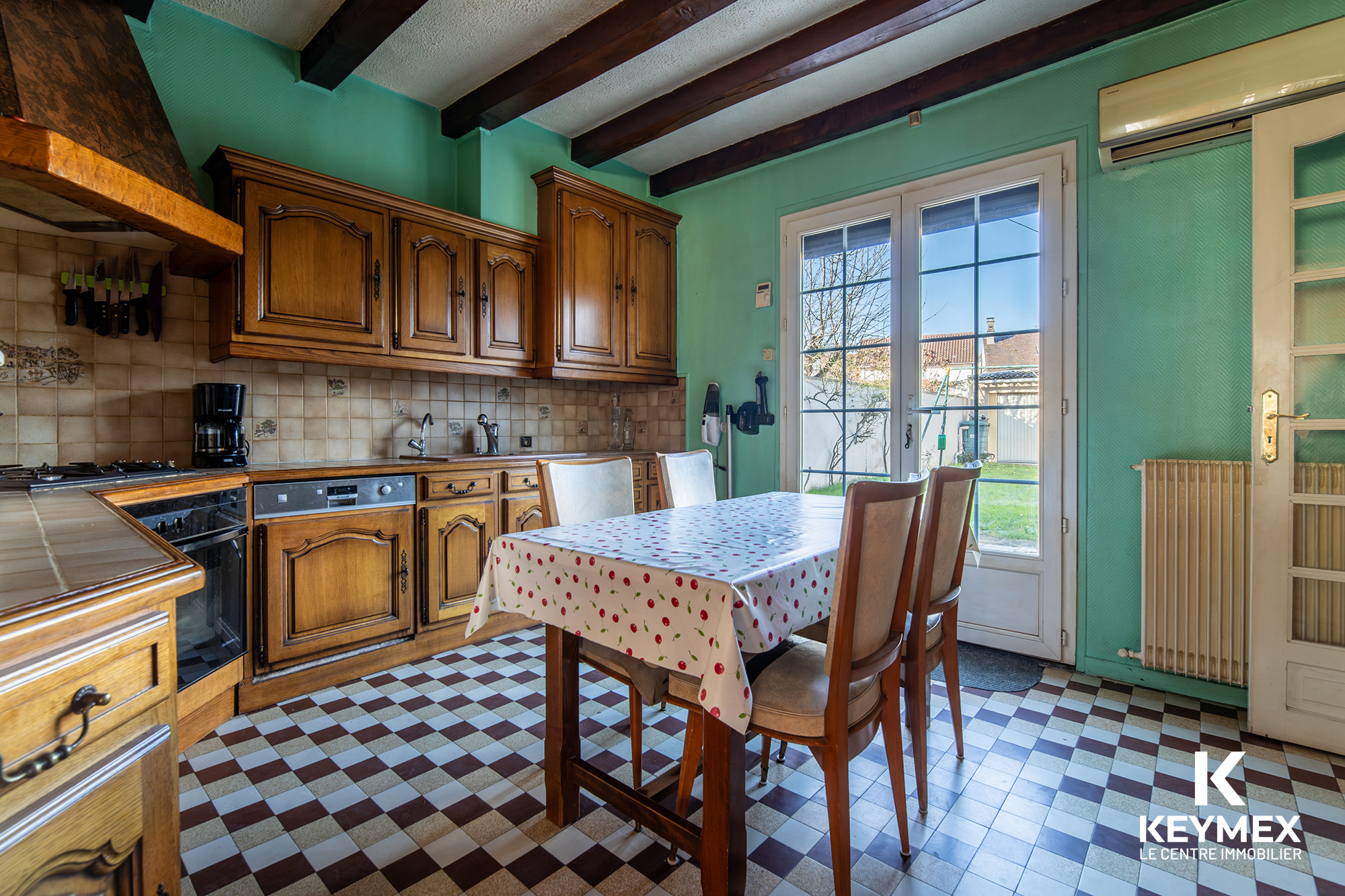 Cuisine vintage avec mobilier en bois et table colorée.