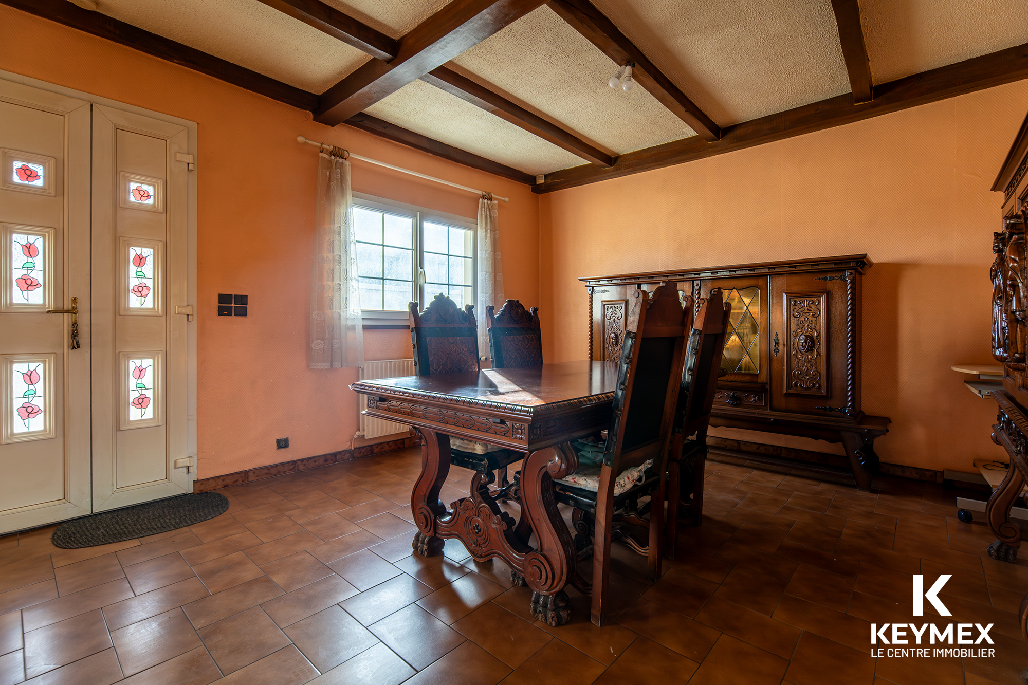 Salle à manger rustique avec meubles en bois sculpté.