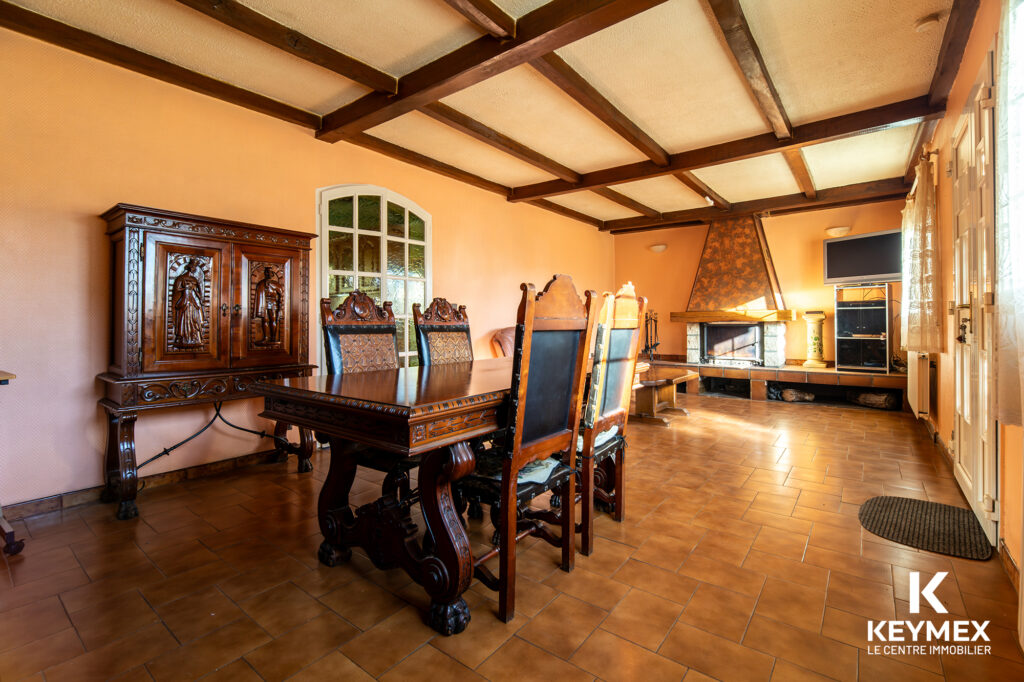 Salle à manger avec cheminée et meubles anciens.