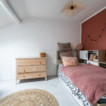 Chambre enfant avec lit et commode en bois.