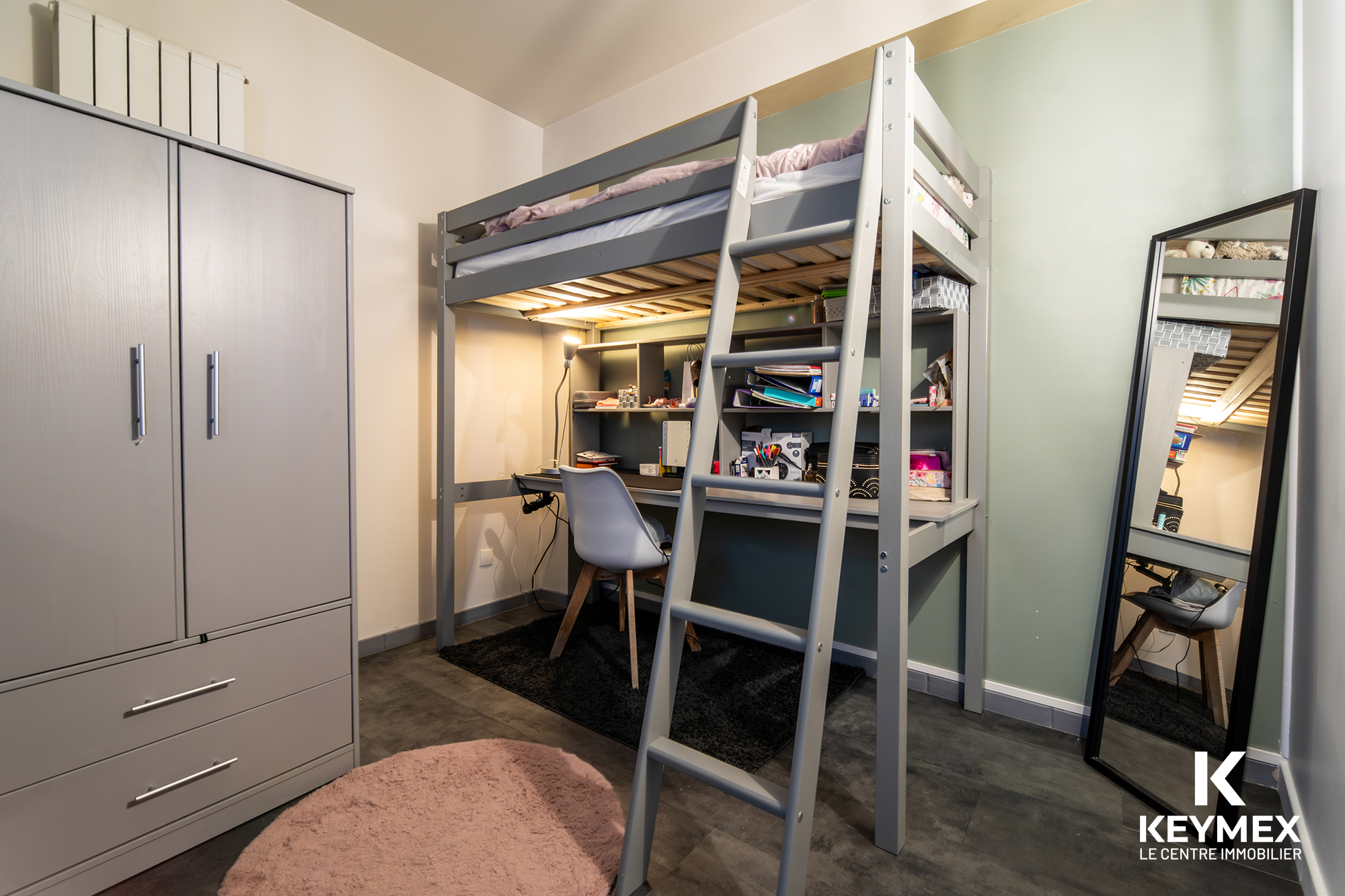 Chambre avec lit mezzanine et bureau intégré.