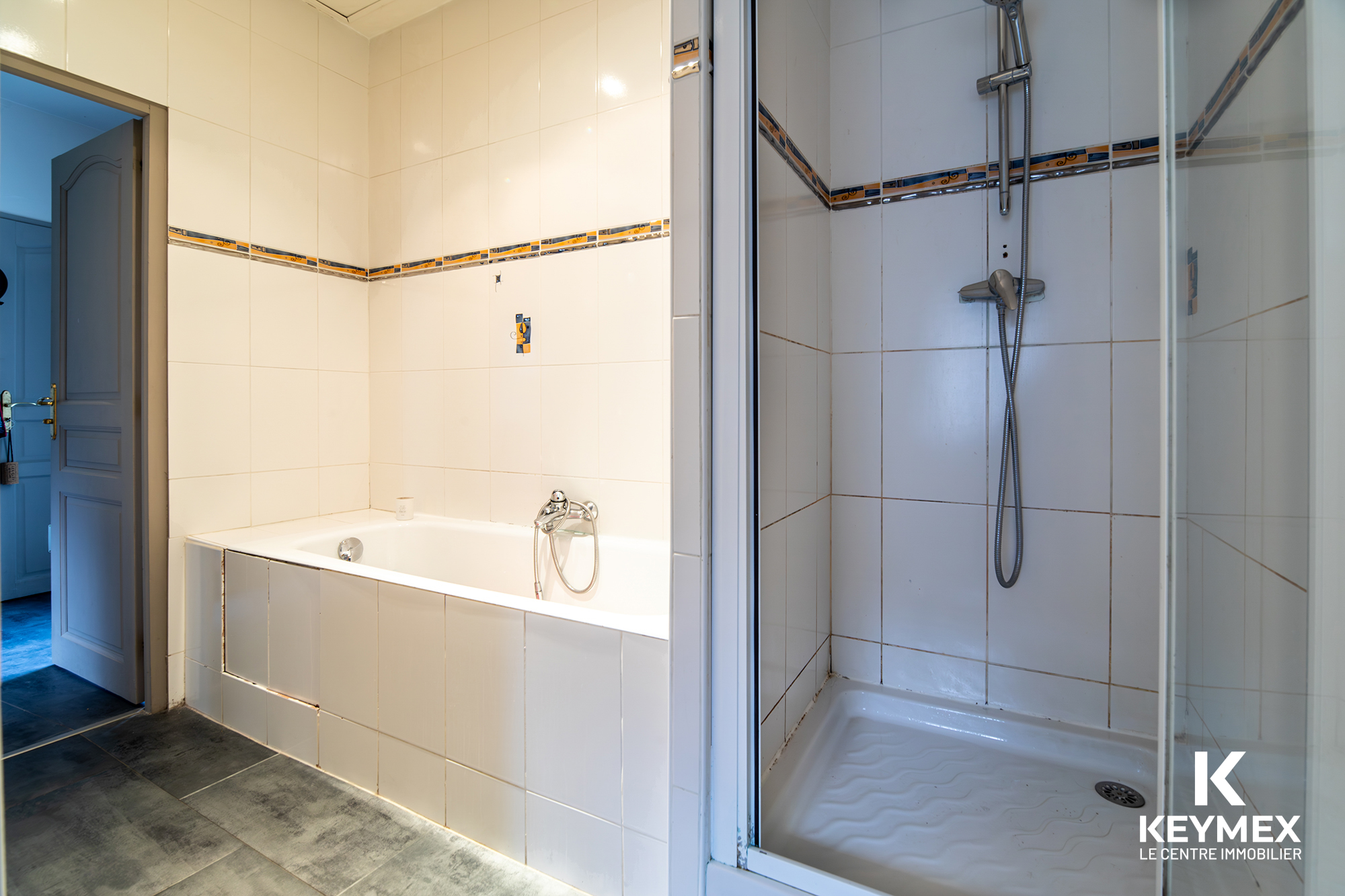 Salle de bain avec baignoire et douche moderne.