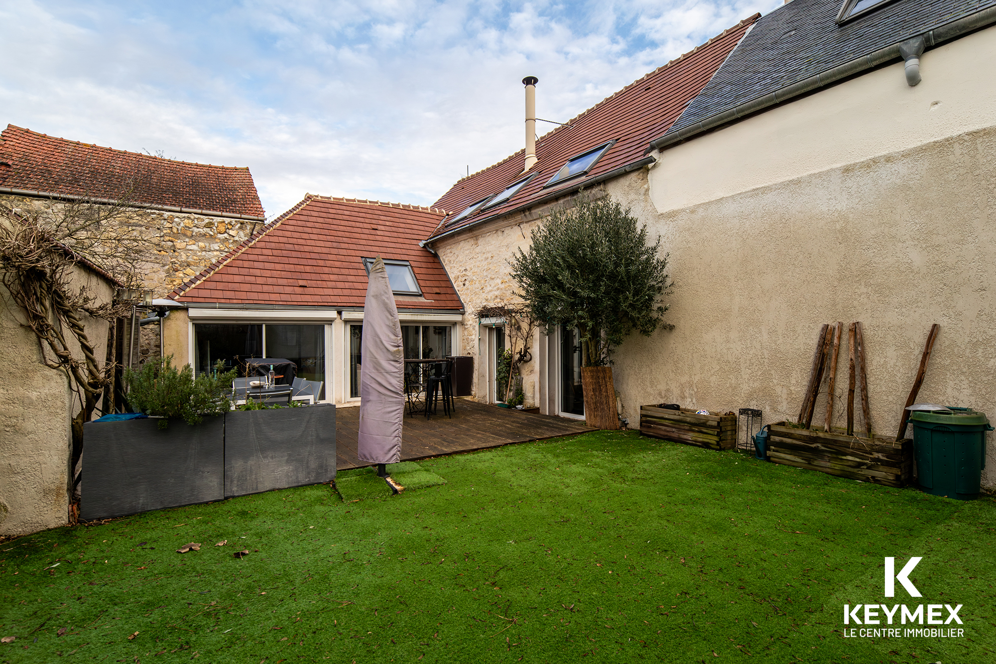 Jardin avec terrasse d'une maison en pierre.