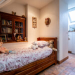 Chambre d'enfant avec lit en bois et peluches.