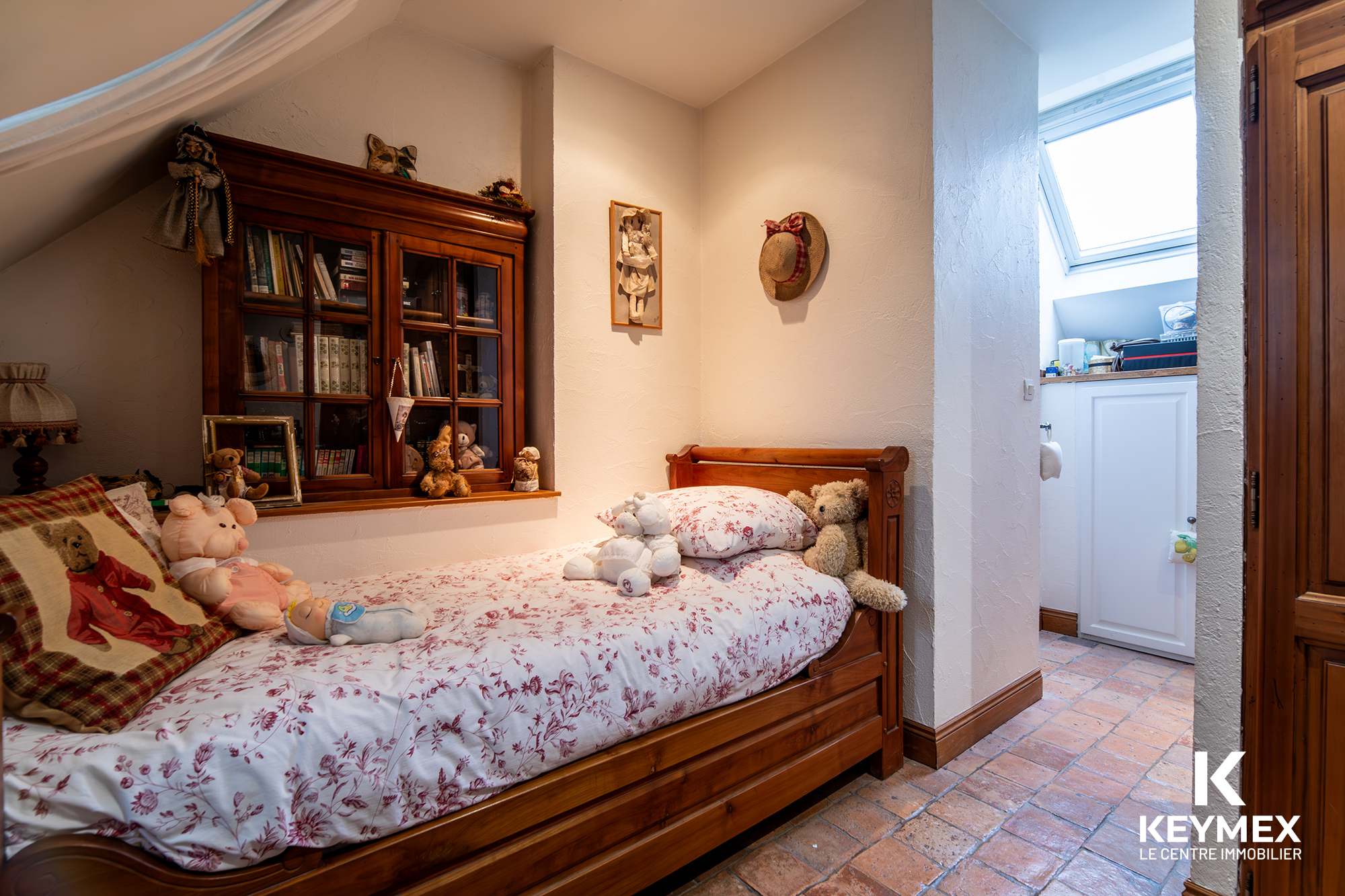 Chambre d'enfant avec lit en bois et peluches.