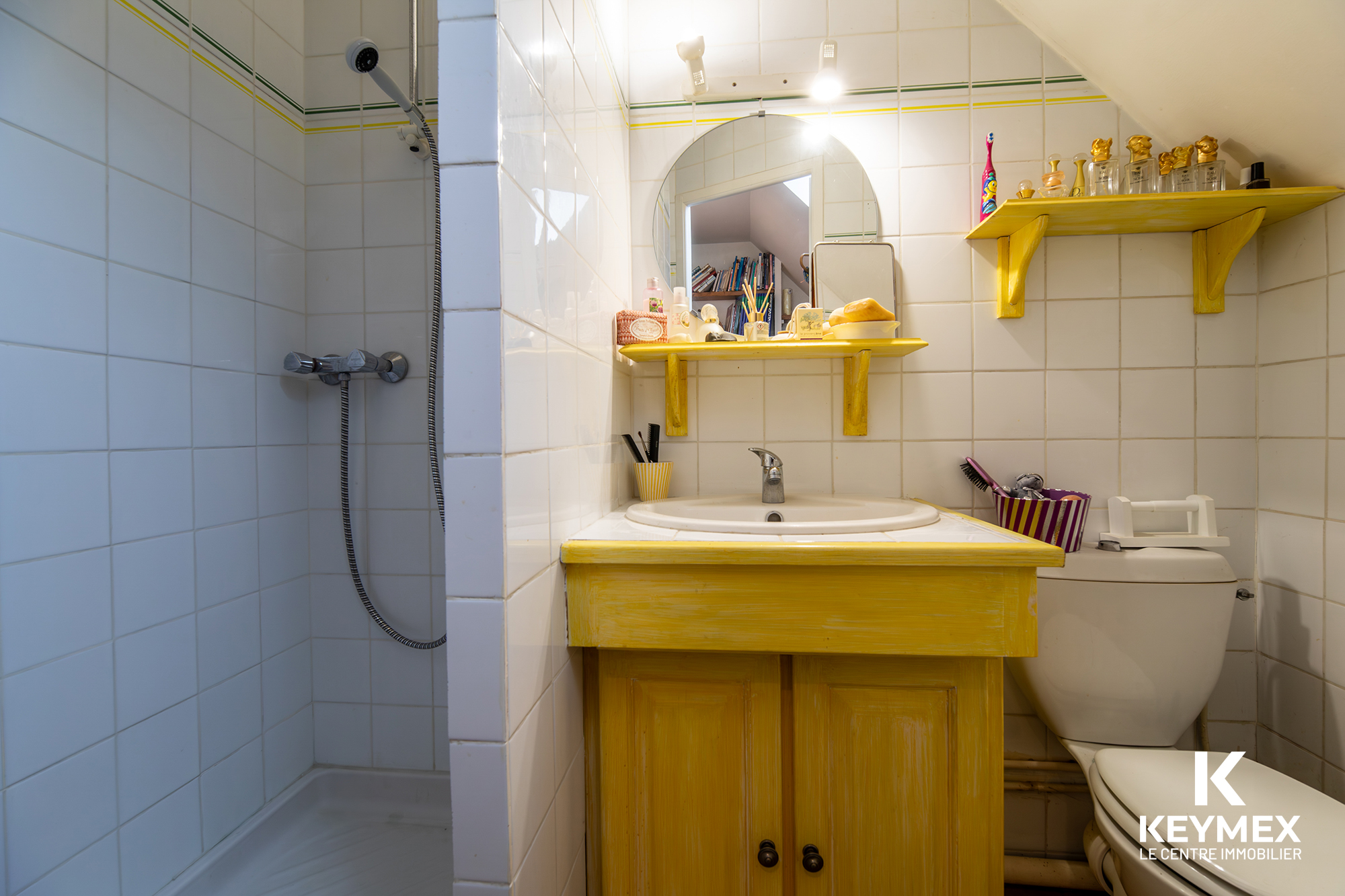 Salle de bain avec douche et lavabo jaune