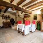 Salle à manger rustique avec poutres apparentes et décoration florale.