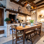 Cuisine rustique avec table en bois et cheminée.