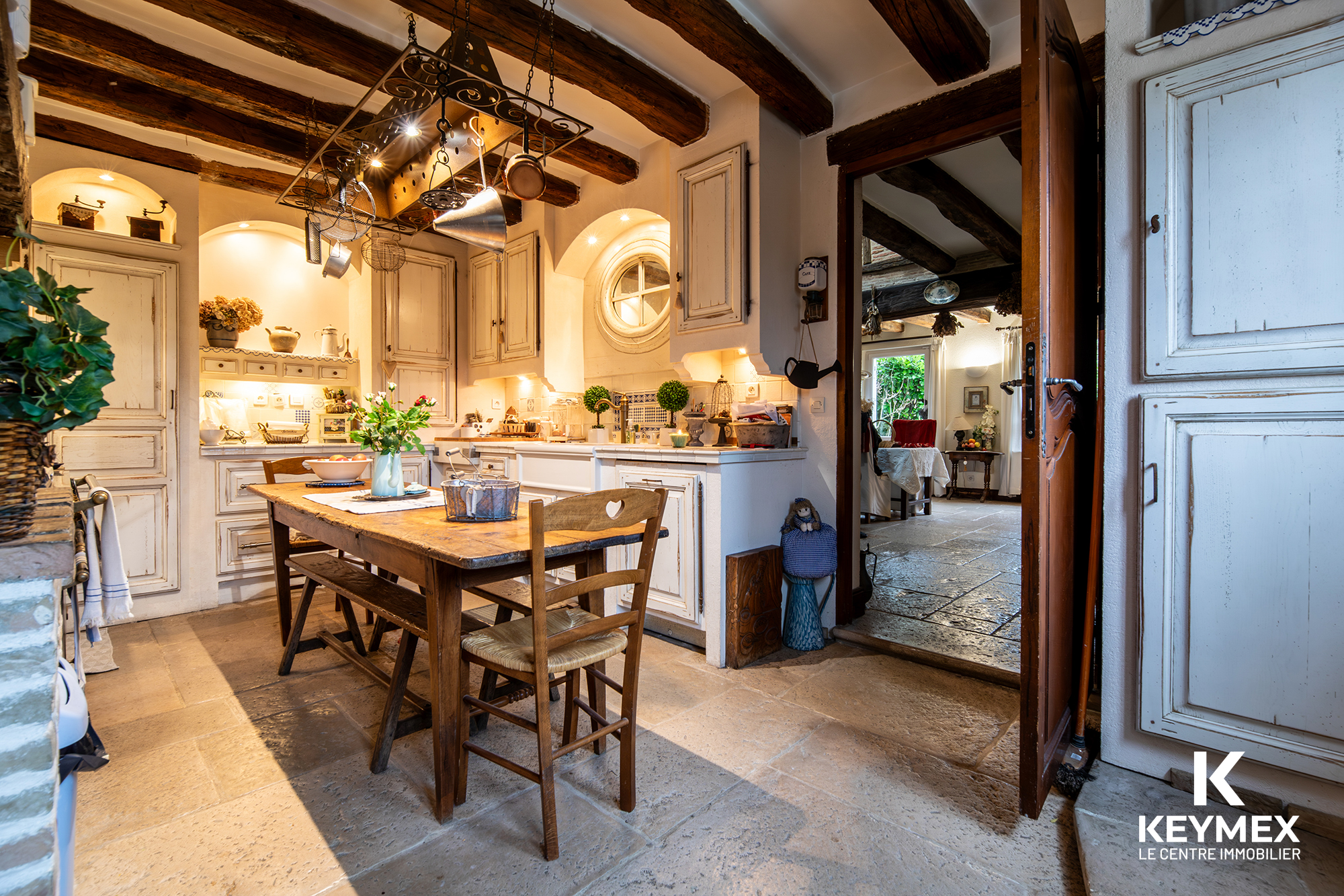 Cuisine rustique avec poutres apparentes et table en bois.