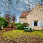 Jardin avec table devant une maison.