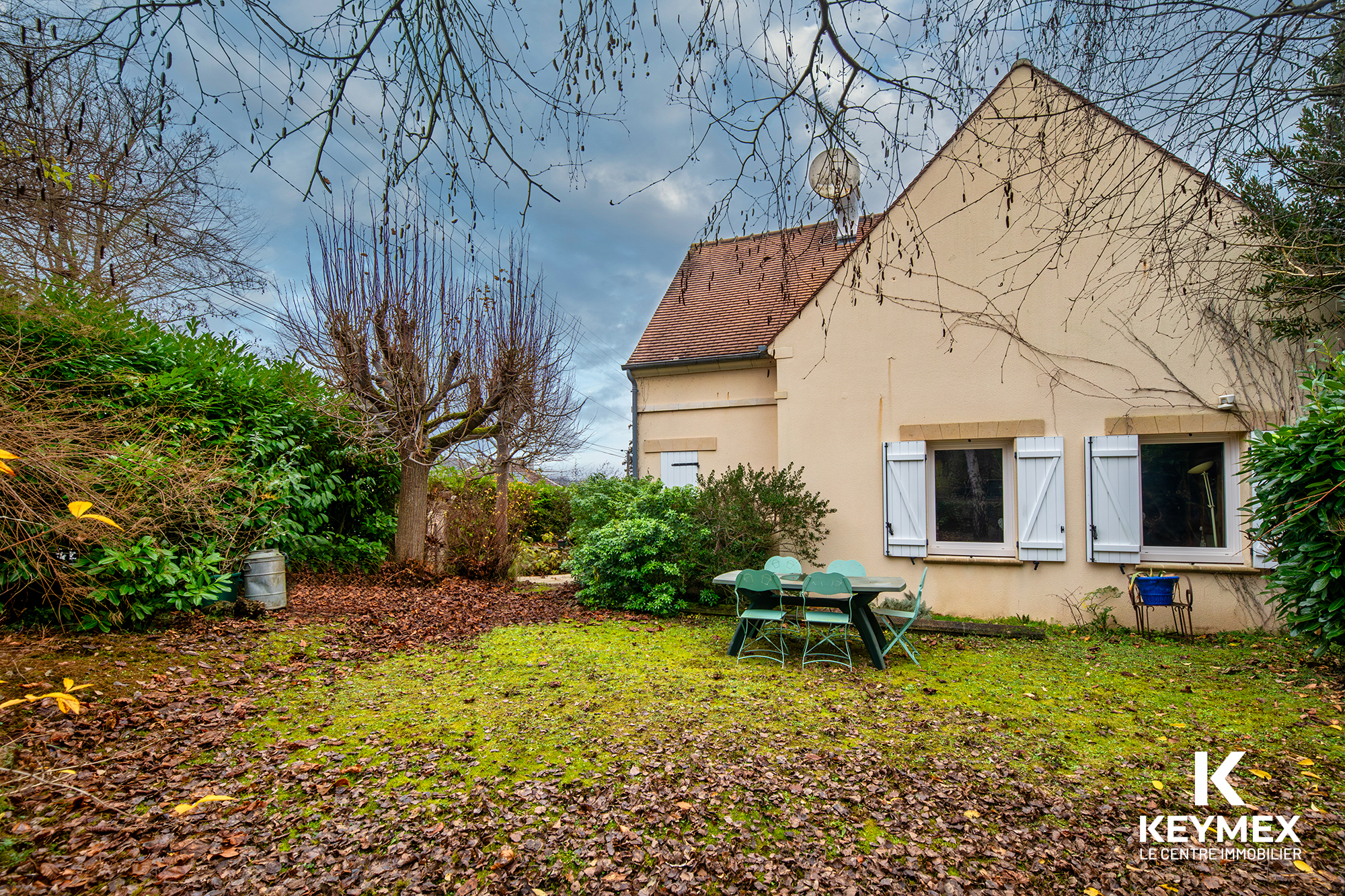 Jardin avec table devant une maison.