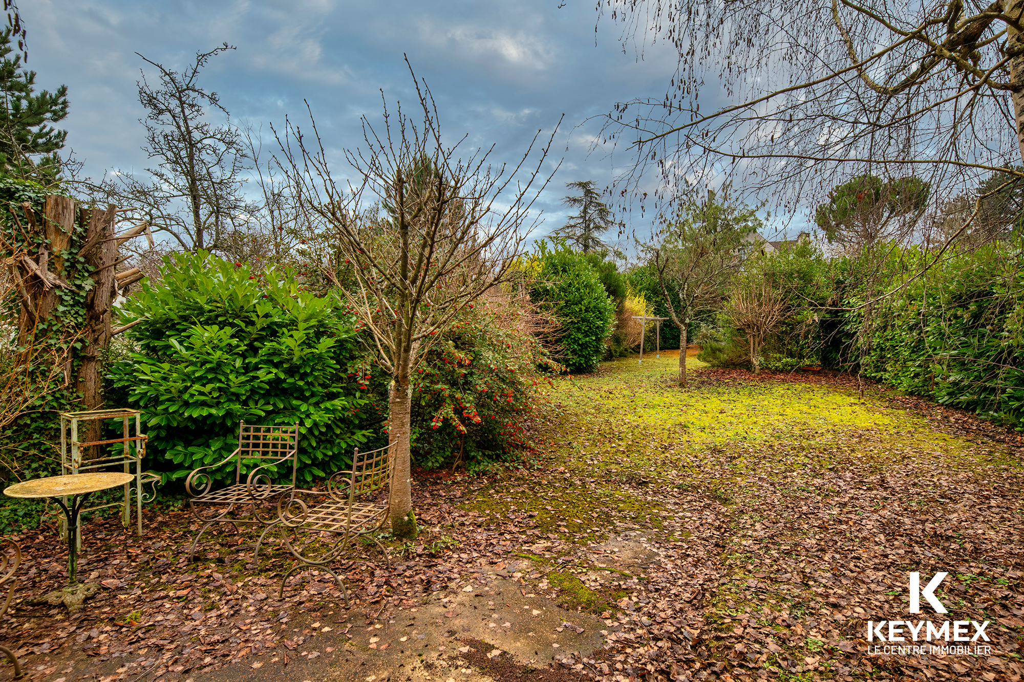 Jardin tranquille avec meubles en métal rouillé.