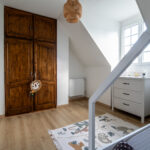 Chambre d'enfant avec armoire en bois et tapis.