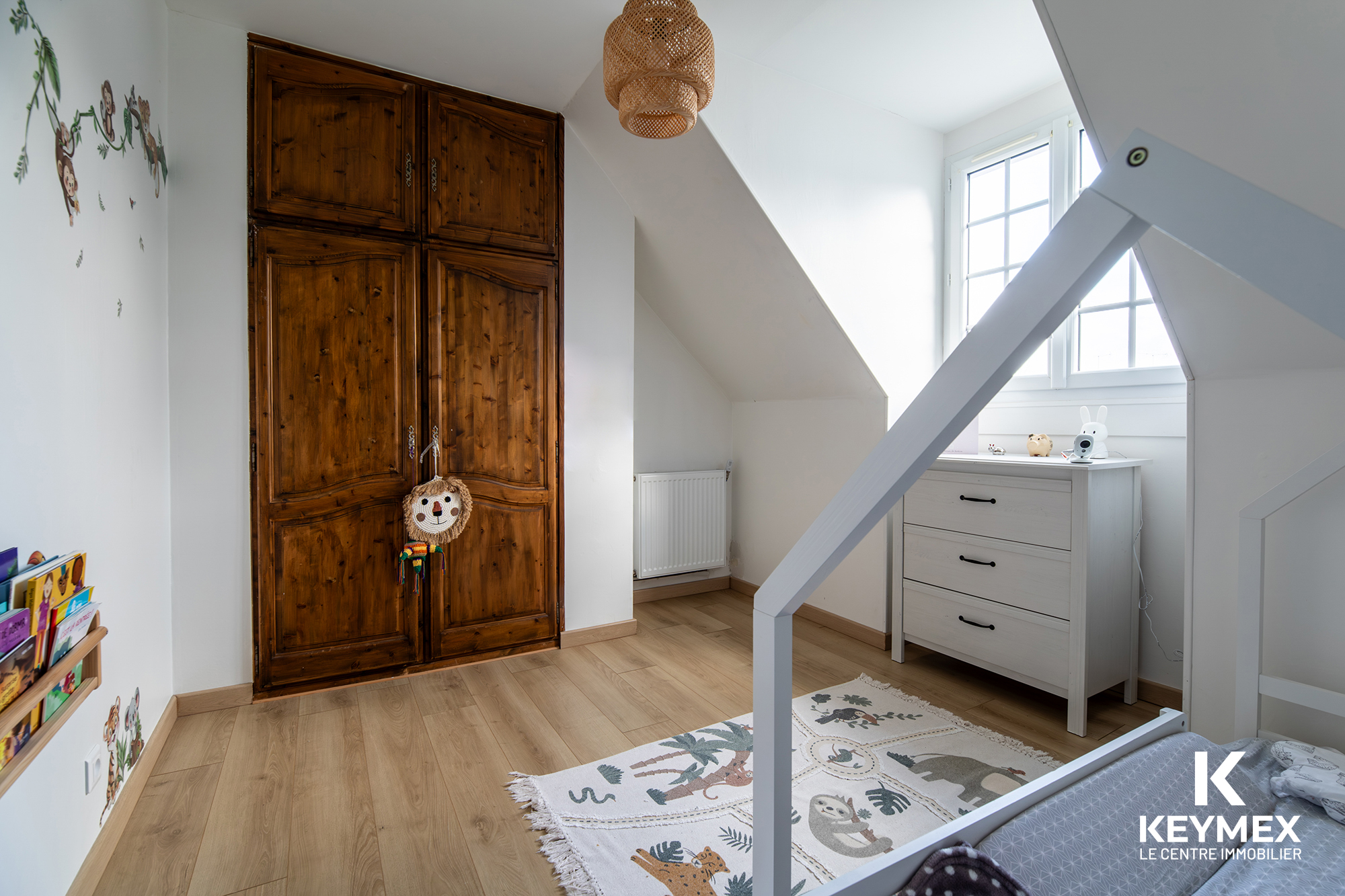 Chambre d'enfant avec armoire en bois et tapis.