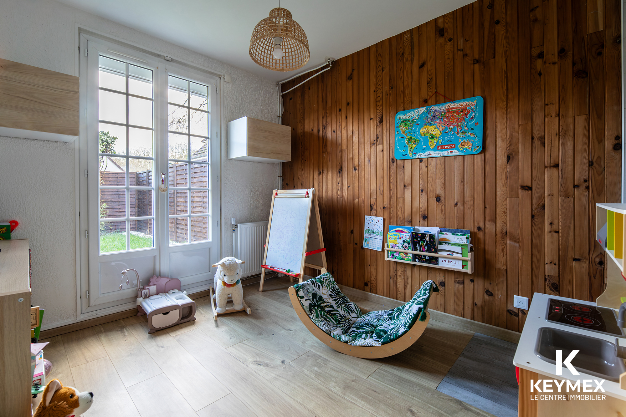 Salle de jeux avec jouets et carte du monde.