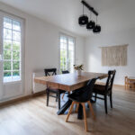 Salle à manger moderne ensoleillée avec table en bois.