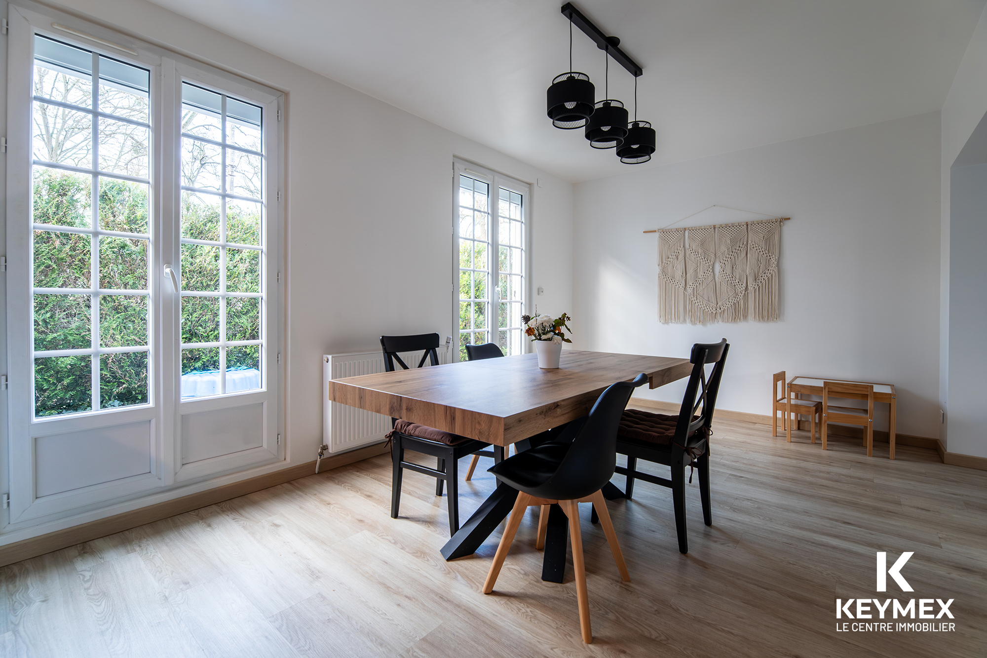 Salle à manger moderne ensoleillée avec table en bois.