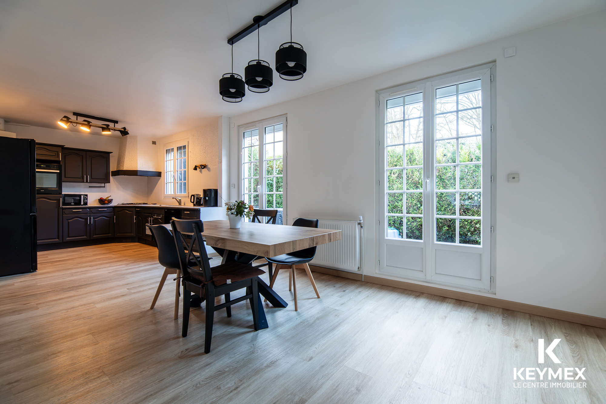 Cuisine moderne avec table et chaises en bois.