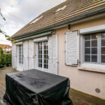 Terrasse maison avec fenêtres et volets blancs