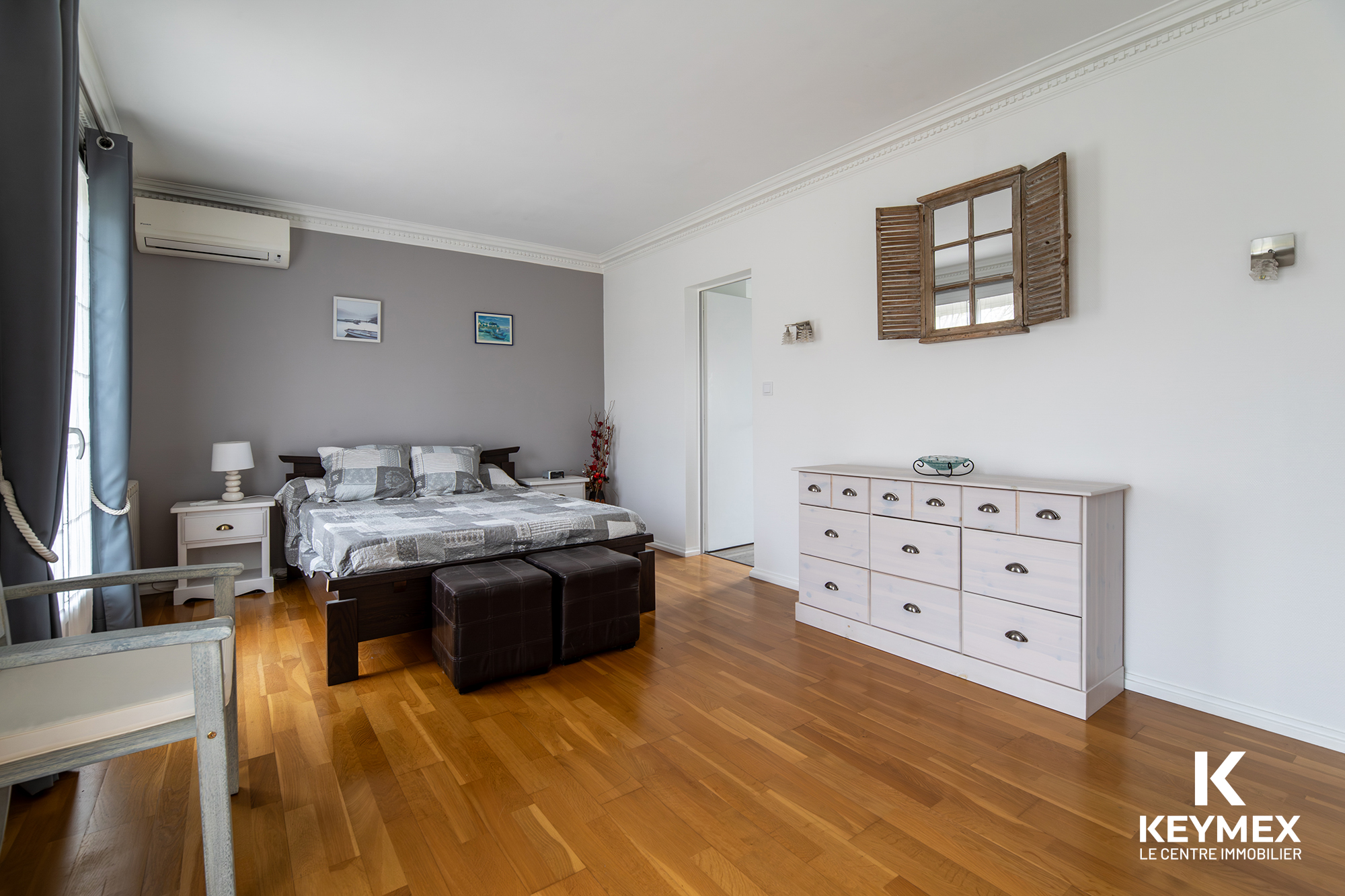 Chambre moderne avec parquet et décoration sobre.