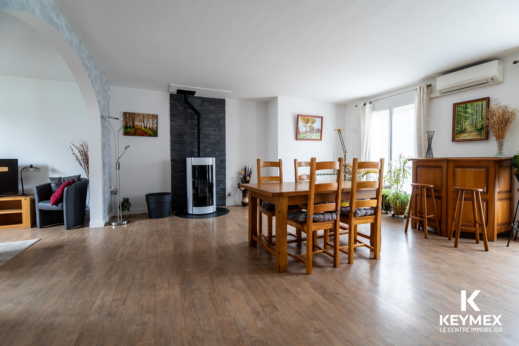 Salon moderne avec poêle et table en bois.