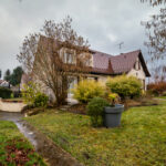 Maison avec jardin en hiver, ciel nuageux