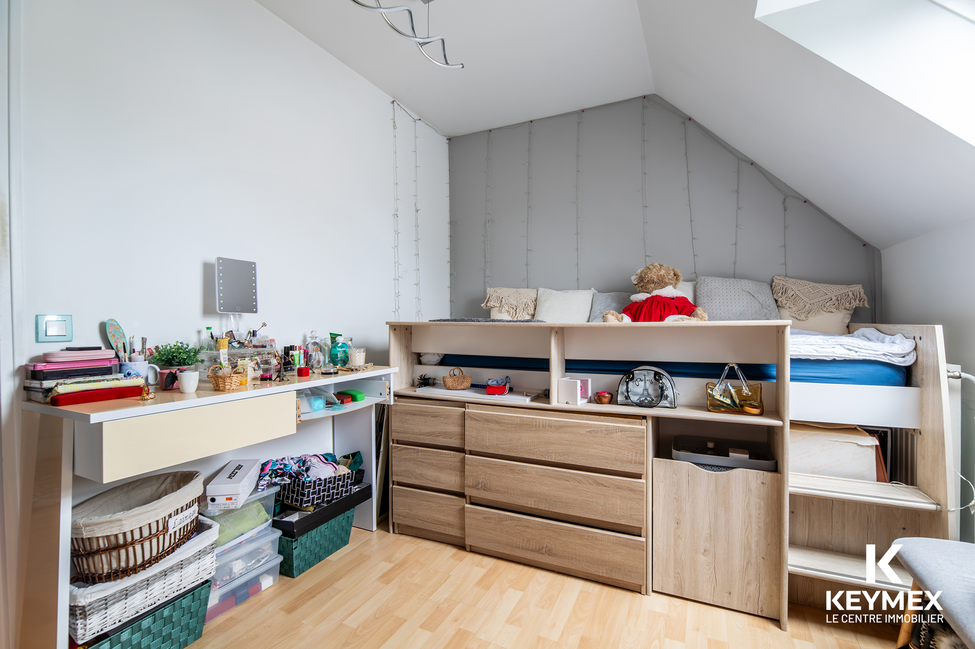 Chambre moderne avec mezzanine et rangement organisé.