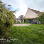 Jardin arrière avec cabane et verdure luxuriante.