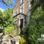 Maison en pierre avec jardin devant.