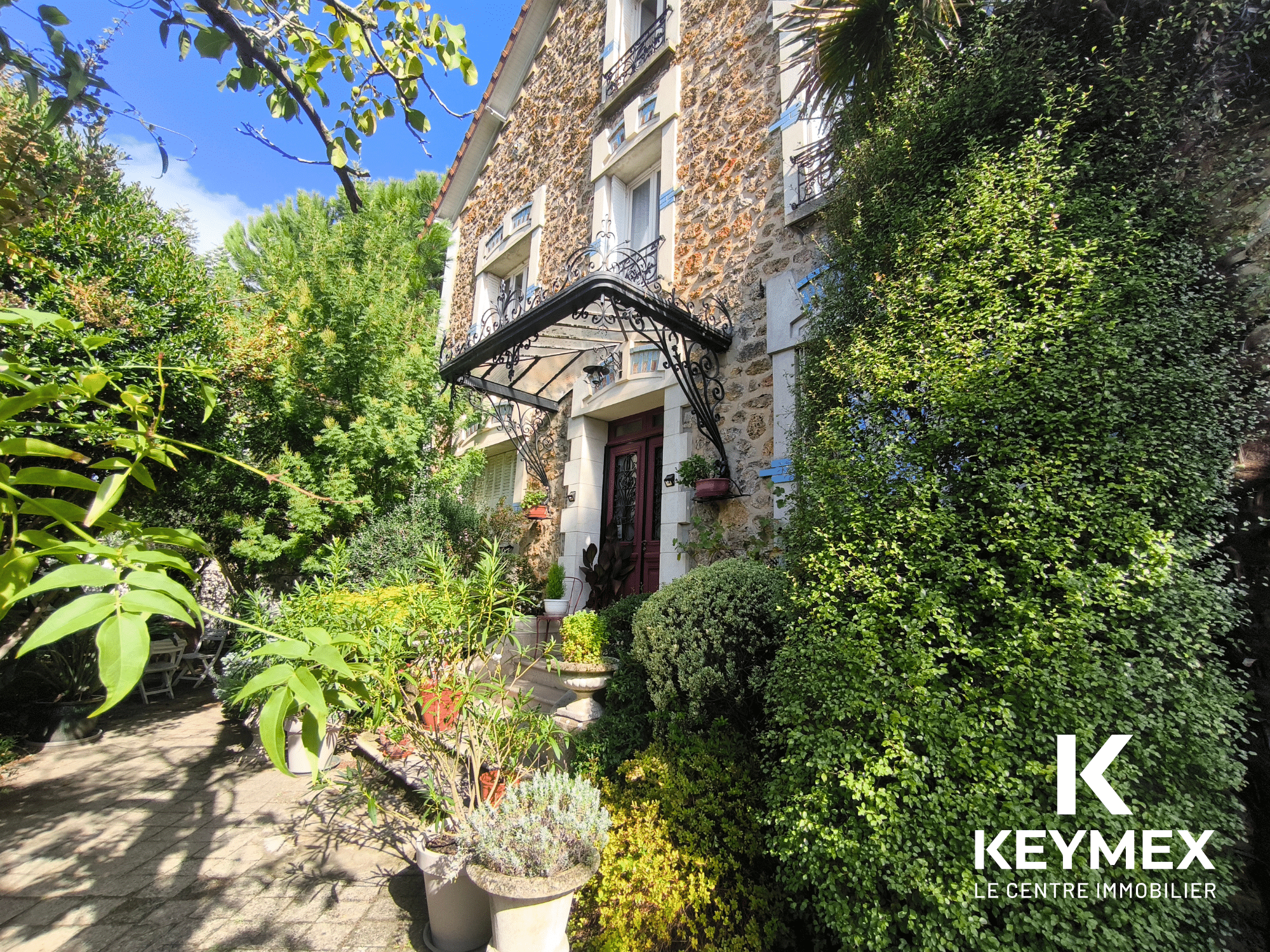 Maison en pierre avec jardin devant.