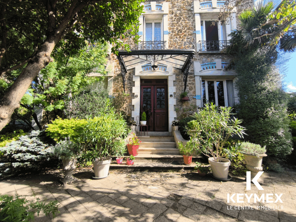 Entrée de maison entourée de plantes verdoyantes