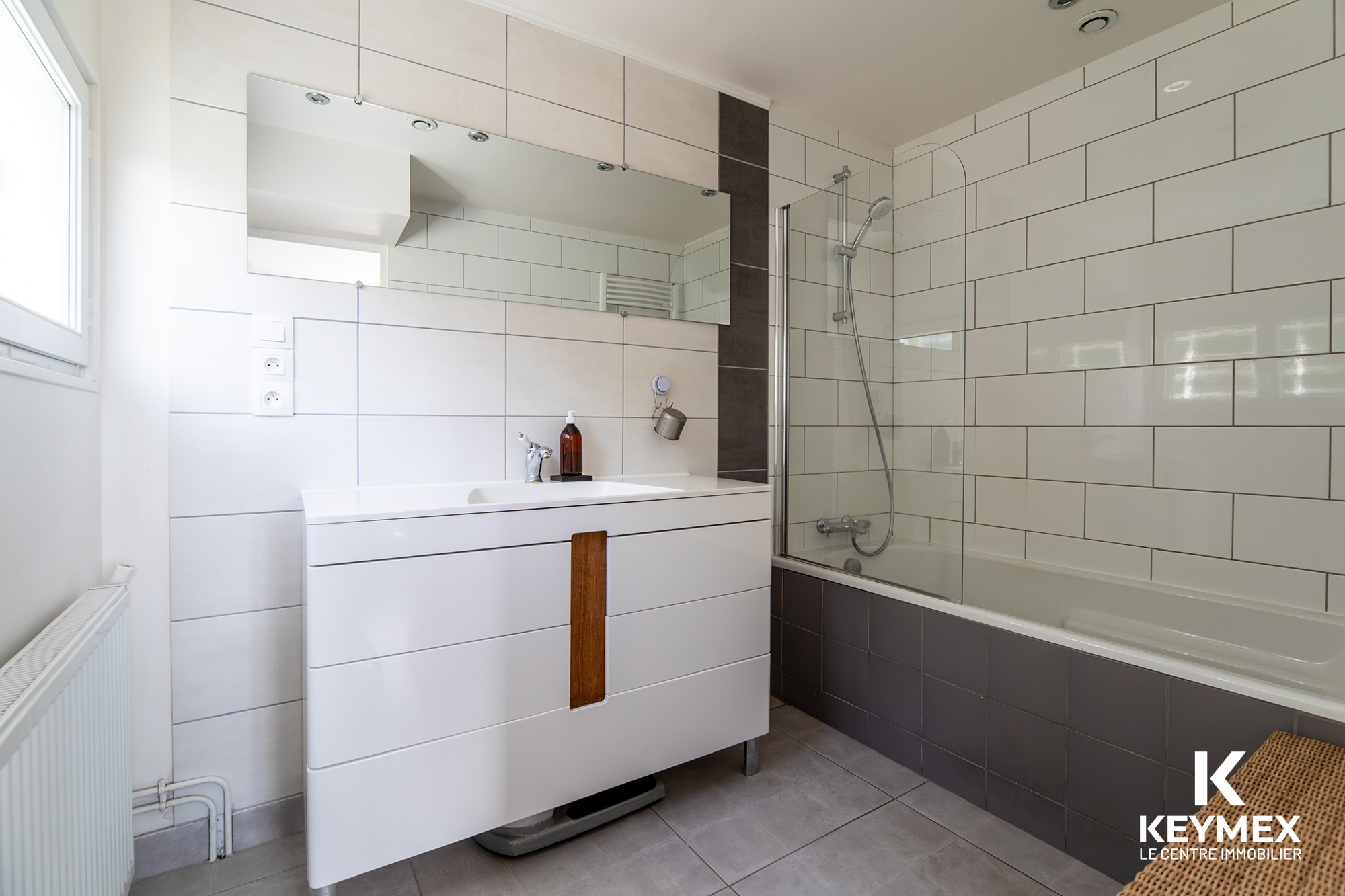 Salle de bain moderne avec baignoire et lavabo.