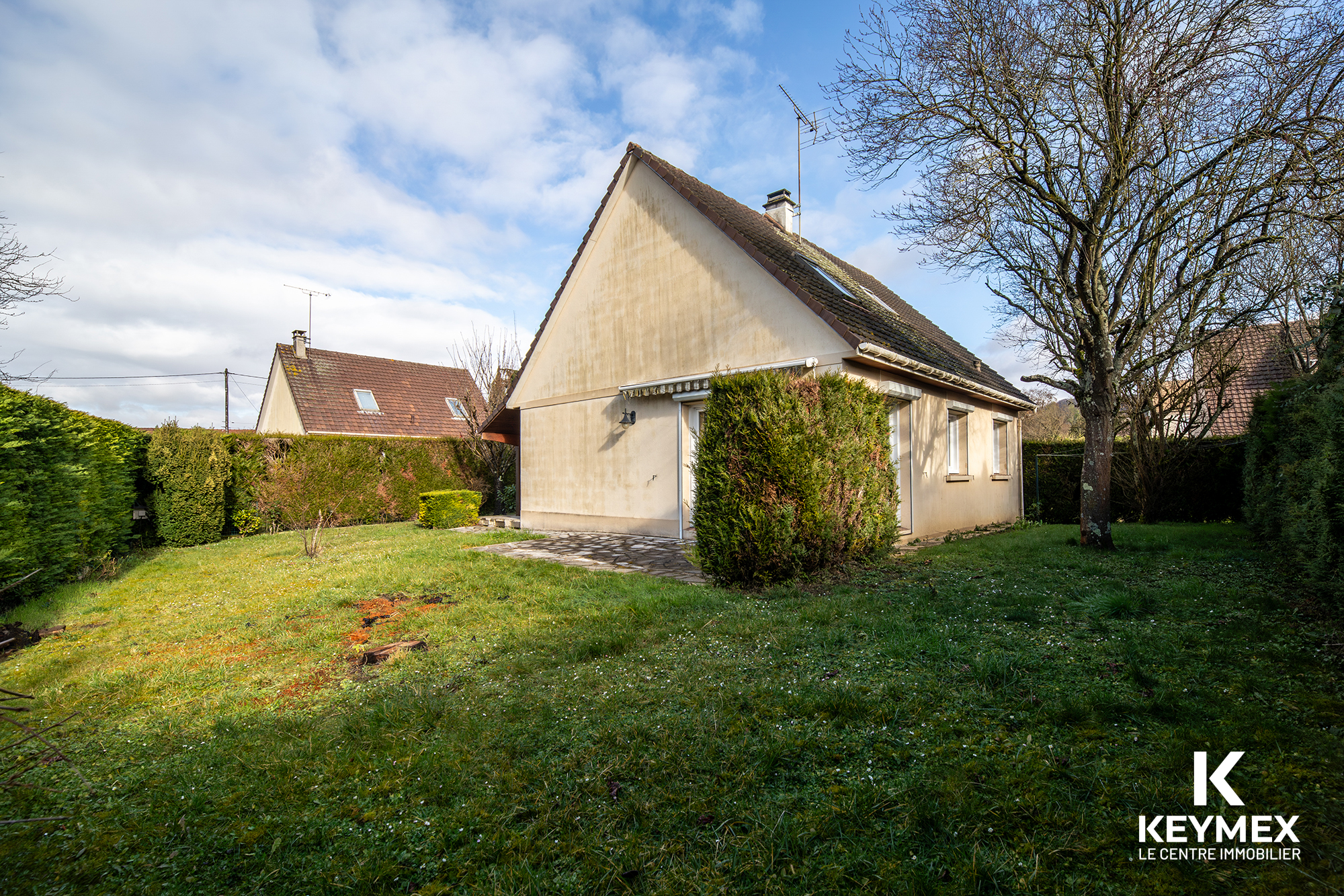 Jardin et maison avec façade beige