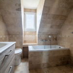 Salle de bain moderne avec baignoire et lavabo.