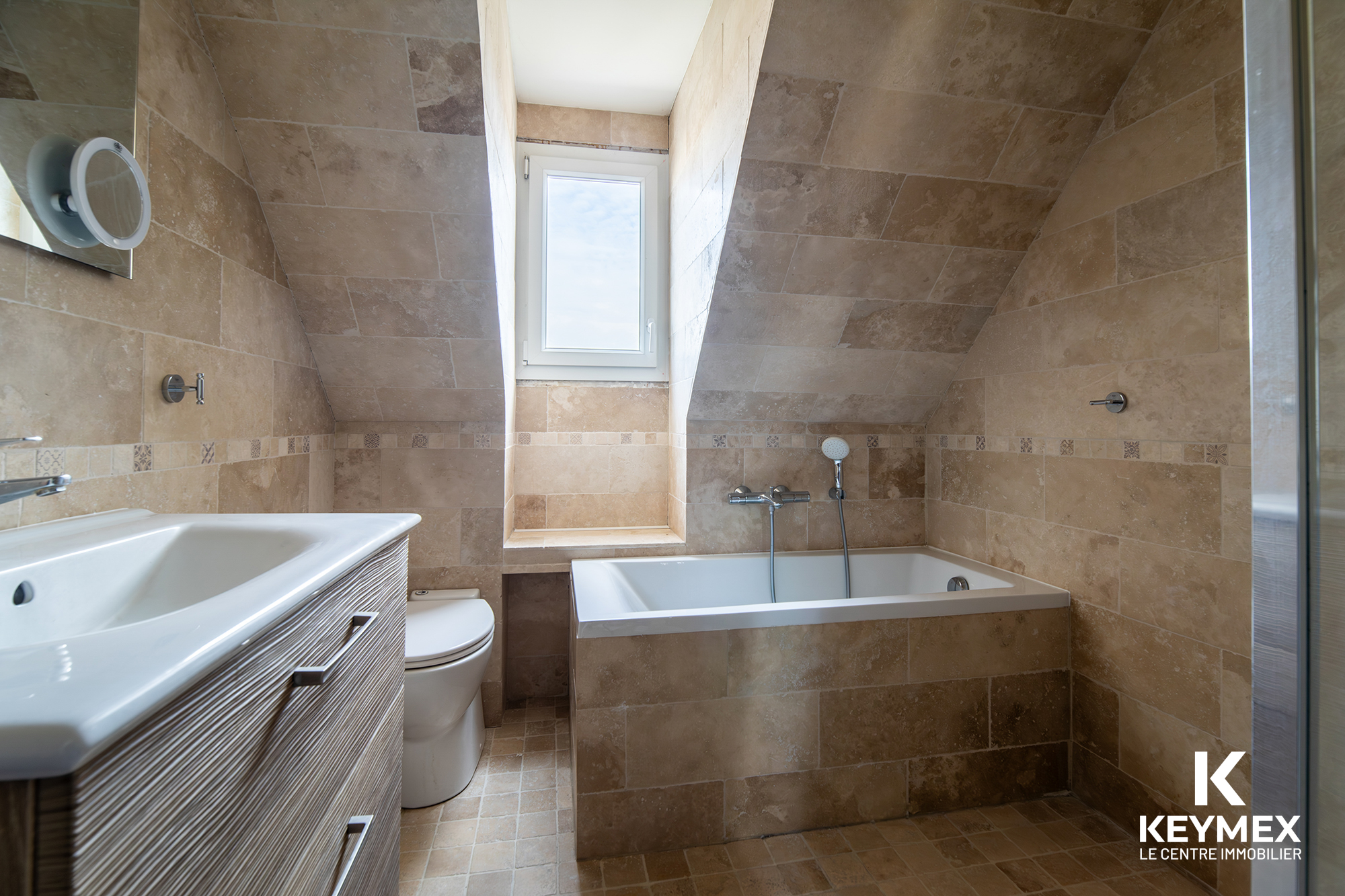 Salle de bain moderne avec baignoire et lavabo.