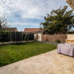 Jardin avec trampoline et terrasse pavée