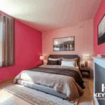 Chambre moderne avec murs roses et lit double.