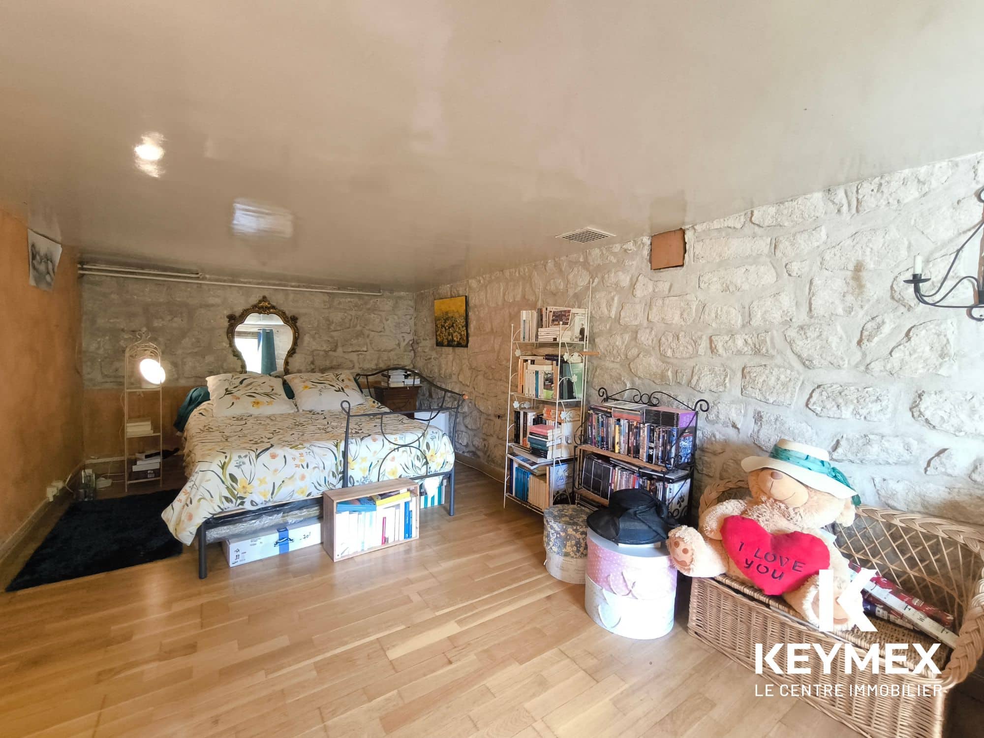 Chambre rustique avec murs en pierre apparente.