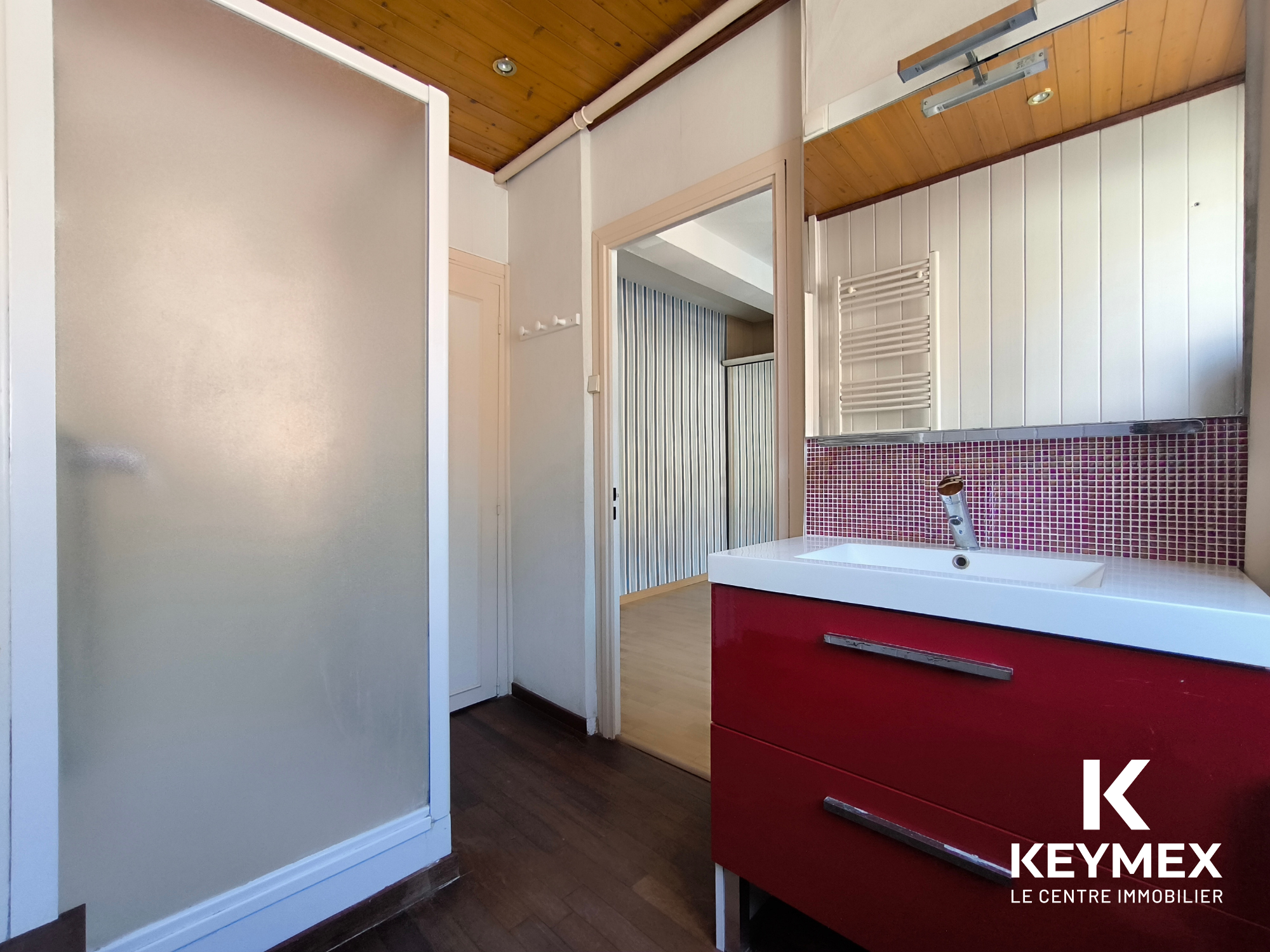 Salle de bain moderne avec lavabo rouge.