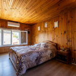Chambre avec mur en bois et lit simple.