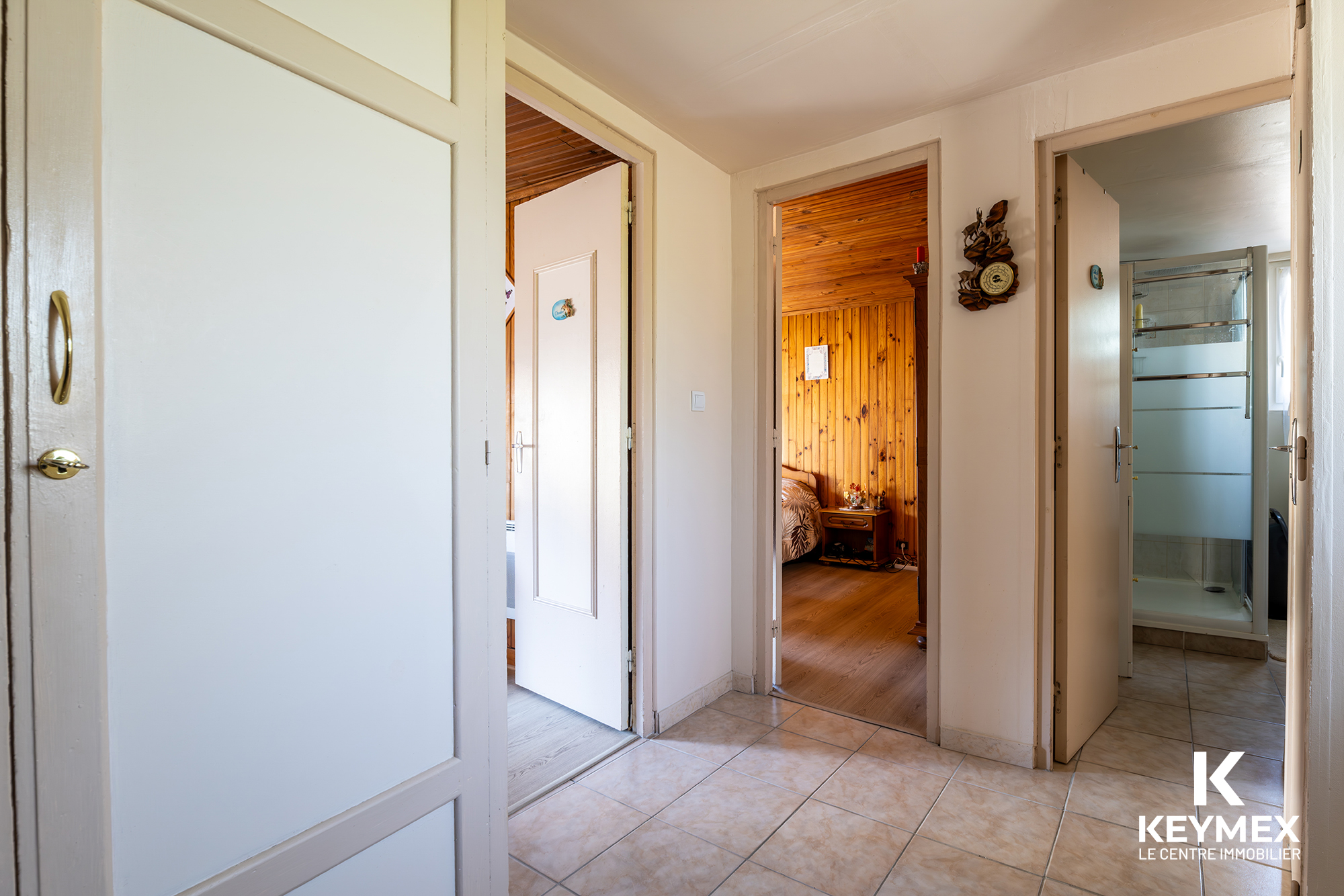Hall d'entrée avec portes vers chambres et salle de bain.