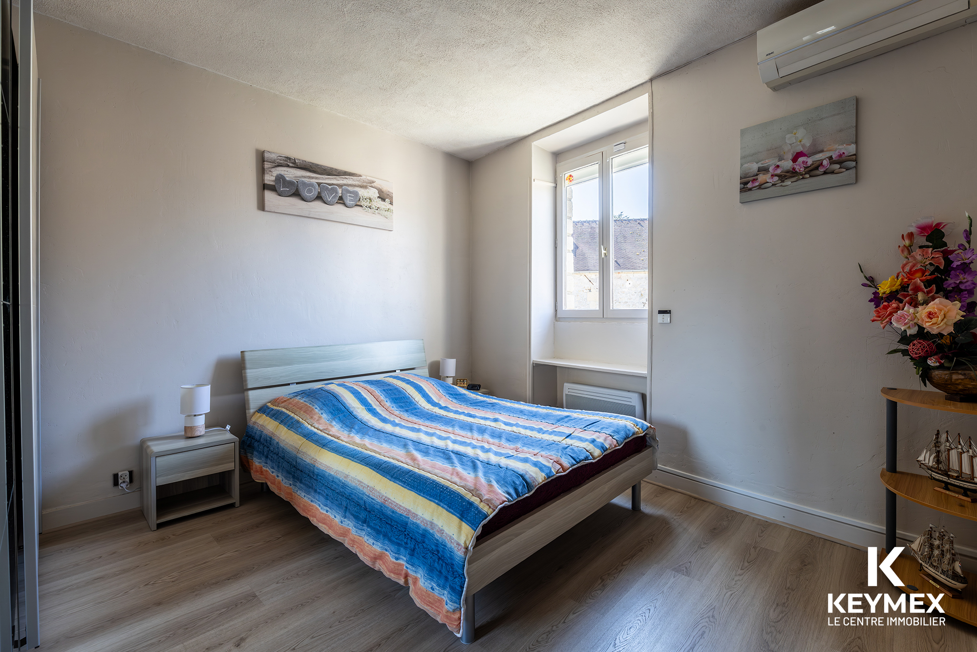 Chambre lumineuse avec lit double et décoration moderne.