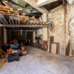 Garage rustique avec outils et matériaux entreposés.
